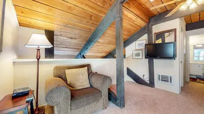 a living room with a chair and a tv at Bigwood #62 Condo in Mammoth Lakes