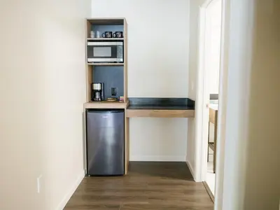 a small kitchen with a refrigerator and a microwave at Cedar Lodge in El Portal