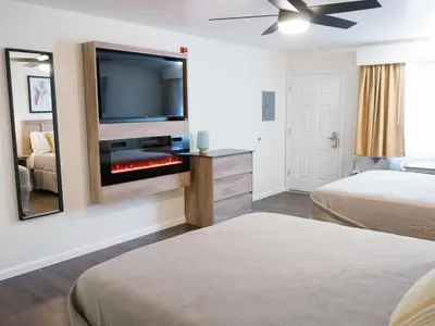 a room with two beds and a flat screen tv at Cedar Lodge in El Portal