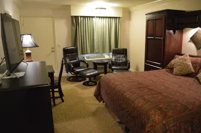 a hotel room with a bed and a table and chairs at Cedar Lodge in El Portal