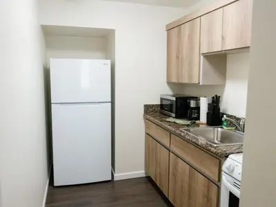 a kitchen with a white refrigerator and a sink at Cedar Lodge in El Portal
