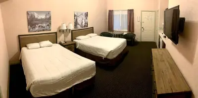 a hotel room with two beds and a flat screen tv at Yosemite View Lodge in El Portal