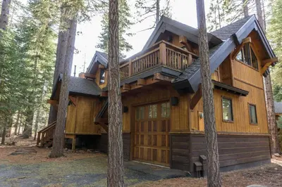 a tree house in the woods with a wrap around porch at 824 Beaver Pond in Truckee