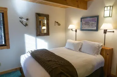 a bedroom with a bed with two lamps and a mirror at 824 Beaver Pond in Truckee