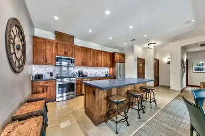 a kitchen with wooden cabinets and a large island with bar stools at Zalanta 328 - HVH3 in South Lake Tahoe