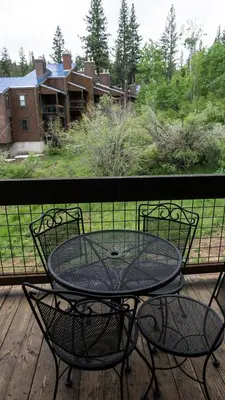a table and chairs on a deck with a view of a yard at Aspen Grove 3090 in Truckee