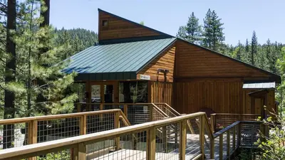 a large wooden cabin with a staircase leading up to it at Catamount 407C in Truckee