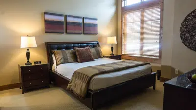 a bedroom with a bed and two lamps and a window at Catamount 407C in Truckee