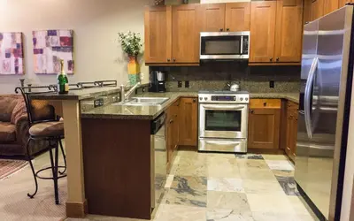 a kitchen with wooden cabinets and stainless steel appliances at Catamount 407C in Truckee