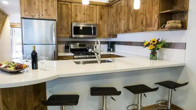 a kitchen with wooden cabinets and a counter with stools at Ski Trails 4070 in Truckee