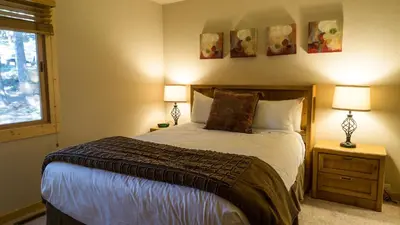 a bedroom with a bed with two lamps and a window at Ski Trails 4113 in Truckee