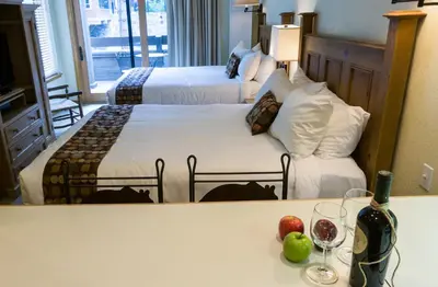 a hotel room with two beds and a table with wine glasses at Northstar Village 237 in Truckee