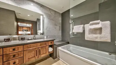 a bathroom with a tub and a sink and a mirror at Zalanta 221 in South Lake Tahoe