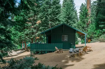 a green cabin in the middle of a forest at Silver City Mountain Resort in Sequoia National Park