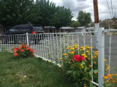 a white fence with flowers on the side of a street at Mount-N-Lake Motel in Wofford Heights