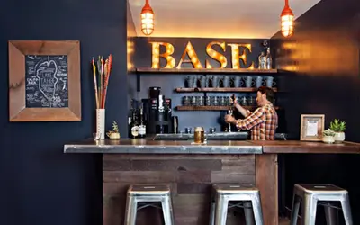 a woman standing at a bar with a glass of wine at Basecamp Tahoe South in South Lake Tahoe