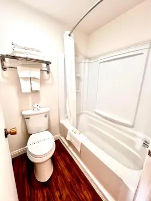 a small bathroom with a toilet and a bath tub at Howard Johnson by Wyndham Downtown Reno in Reno