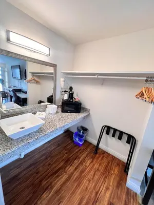 a room with a counter with a sink and a mirror at Howard Johnson by Wyndham Downtown Reno in Reno