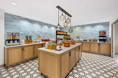 a large kitchen with wooden cabinets and a counter at Hampton Inn Morgan Hill in Morgan Hill