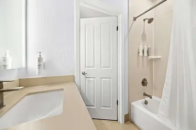a white bathroom with a tub and a shower at Hampton Inn Morgan Hill in Morgan Hill