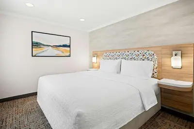 a hotel room with a white bed and a painting at Hampton Inn Morgan Hill in Morgan Hill