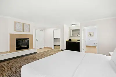 a white bedroom with a bed and a fireplace at Hampton Inn Morgan Hill in Morgan Hill