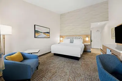 a hotel room with a bed and two chairs at Hampton Inn Morgan Hill in Morgan Hill