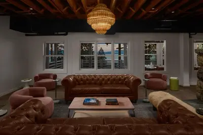 a living room with brown leather furniture and a chandelier at evo Hotel Tahoe City in Tahoe City
