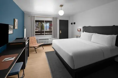 a bedroom with a large white bed and a desk at evo Hotel Tahoe City in Tahoe City