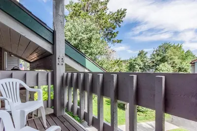 a wooden porch with a white chair and a fence at Snowcreek IV 598 in Mammoth Lakes