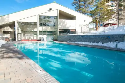 a blue swimming pool in front of a building at The Ridge Sierra in Stateline