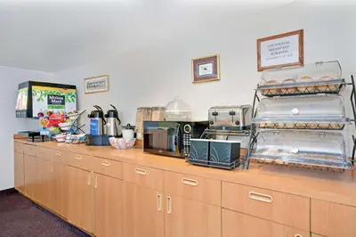 a kitchen with a line of wooden cabinets at Microtel Inn & Suites, Morgan Hill in Morgan Hill