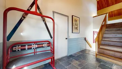 a red chair in a hallway with stairs at Bridges Townhome #5 Condo in Mammoth Lakes