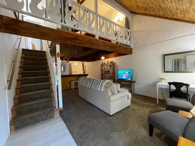 a living room with a staircase and a couch at Sierra Mountain Lodge - Vacation Rentals - Yosemite in Ahwahnee