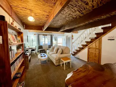 a living room with a couch and a staircase at Sierra Mountain Lodge - Vacation Rentals - Yosemite in Ahwahnee