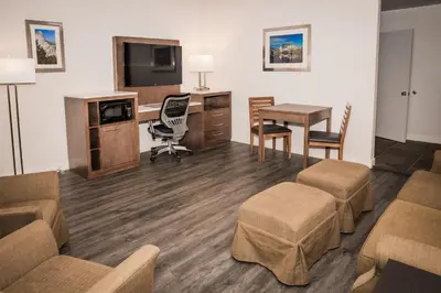 a hotel room with a desk and a table and chairs at Best Western Bishop Lodge in Bishop