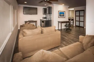 a living room with a couch and a flat screen tv at Best Western Bishop Lodge in Bishop