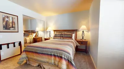 a bedroom with a large bed and two lamps at Snowcreek 622 Condo in Mammoth Lakes