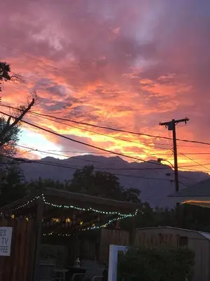 a sunset with christmas lights in front of a fence at Independence Courthouse Motel in Independence