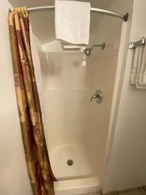 a shower in a bathroom with a shower curtain at Independence Courthouse Motel in Independence
