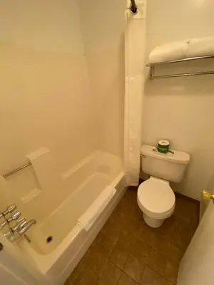 a bathroom with a toilet and a bath tub and a toilet at Independence Courthouse Motel in Independence