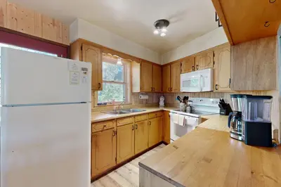 a kitchen with wooden cabinets and a white refrigerator at Rustic Retreat in Groveland