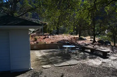 a picnic table and a bench next to a building at Shady Knoll in Three Rivers