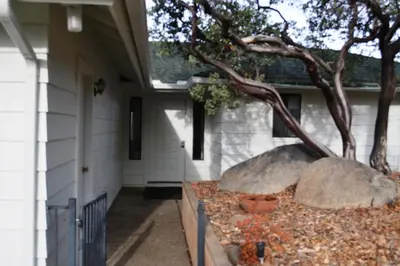 a house with two large rocks and a tree at Shady Knoll in Three Rivers