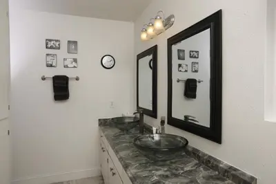a bathroom with two sinks and a large mirror at Shady Knoll in Three Rivers