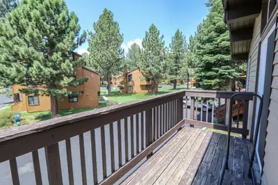 a balcony with a wooden railing and trees at Timberline Condominium #44 in Mammoth Lakes