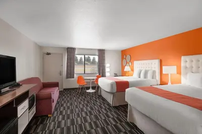a hotel room with two beds and a flat screen tv at Howard Johnson by Wyndham Modesto Ceres in Ceres