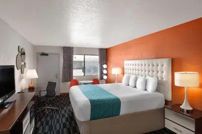 a hotel room with a bed and a desk at Howard Johnson by Wyndham Modesto Ceres in Ceres