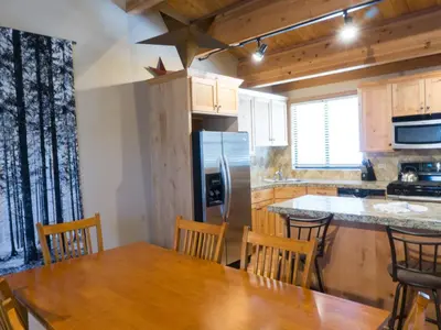 a kitchen with a wooden table and a refrigerator at 3130 Aspen Grove in Truckee