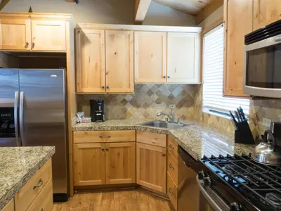 a kitchen with wooden cabinets and a stainless steel refrigerator at 3130 Aspen Grove in Truckee